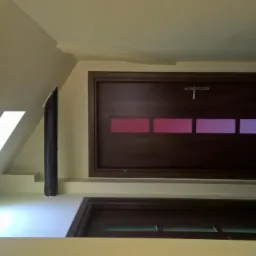 Wnętrze z dwiema drewnianymi drzwiami w kolorze ciemnego brązu, górne drzwi z poziomym paskiem z kolorowymi szybami w odcieniach różu i fioletu, dolne drzwi z szybami w kolorze zielonym, ściany...