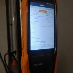 Analizator spalin Testo 300 z wyświetlonym wykresem pomiarów, obudowa w kolorze czarno-pomarańczowym, widoczne wartości temperatury i zawartości CO2.