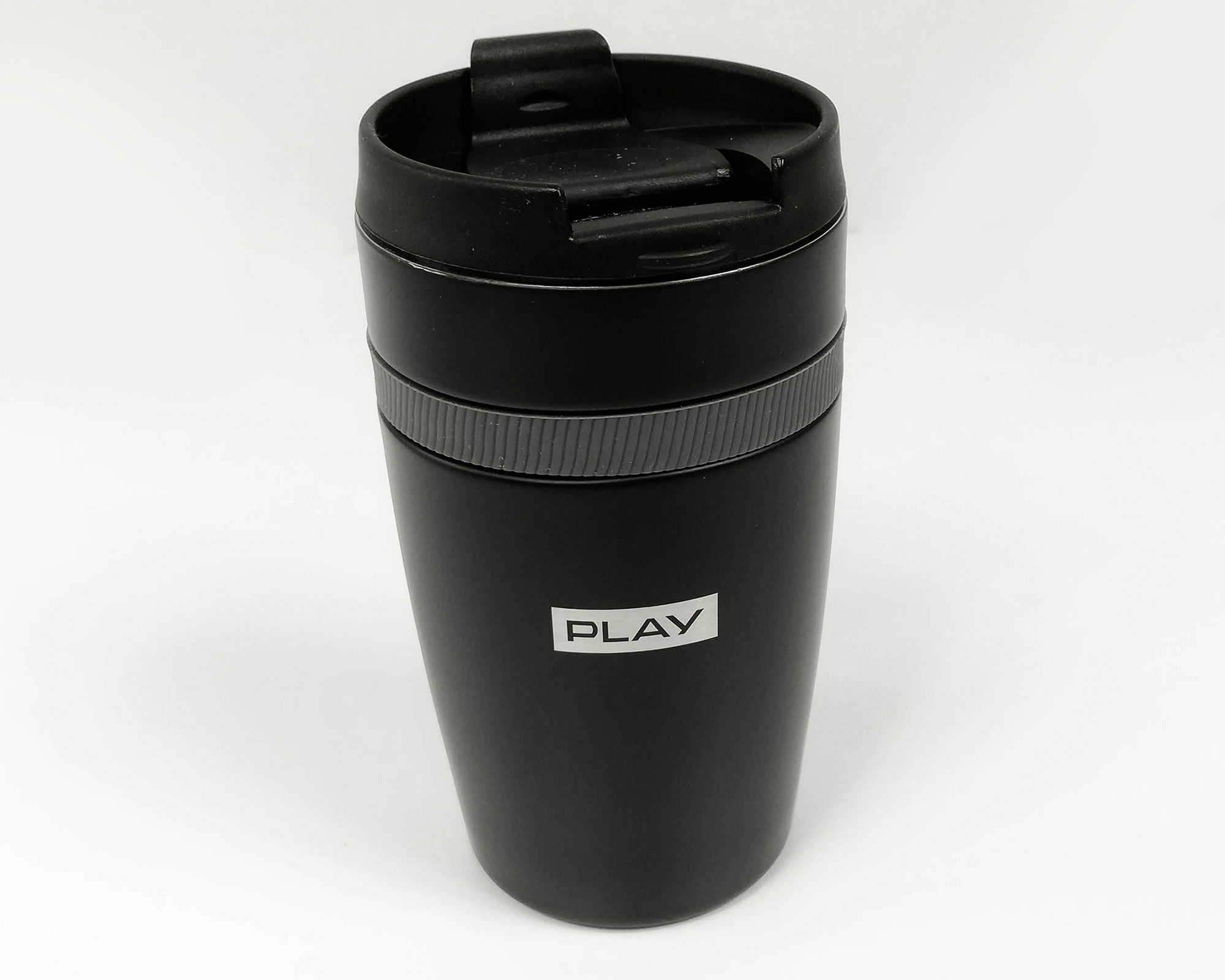 Czarny, matowy kubek termiczny z plastikową nakrętką i napisem 'PLAY' na białym tle, ustawiony na białym tle.