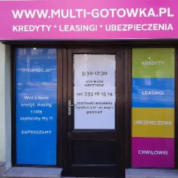 Fasada lokalu z ofertą kredytów, leasingów i ubezpieczeń, z widocznym szyldem 'WWW.MULTI-GOTOWKA.PL' oraz informacjami o promocji i godzinach otwarcia.