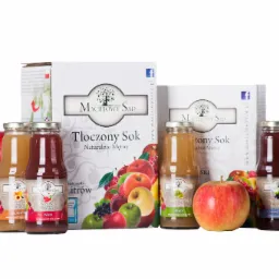 Sok jabłkowy tłoczony, naturalnie mętny, w szklanych butelkach i kartonowych opakowaniach, z dodatkiem brzoskwini, wiśni i mięty, otoczony świeżymi jabłkami na białym tle.