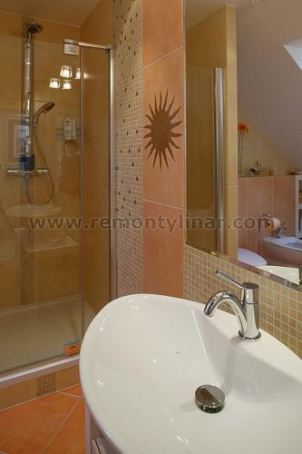 Jasna łazienka z kabiną prysznicową, umywalką na pierwszym planie i dekoracyjnym motywem słońca na ścianie.