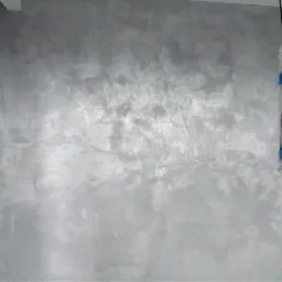 Ściana w Sosnowcu z dekoracyjnym, srebrzystym wykończeniem, zabezpieczone kable elektryczne wiszą obok gniazdka.