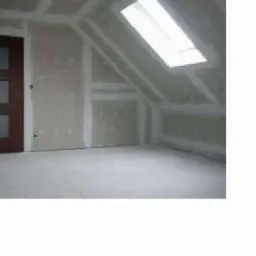 Poddasze z oknem dachowym w trakcie wykańczania płytami gipsowo-kartonowymi, widoczna ciemna drewniana ościeżnica drzwi z trzema przeszkleniami.