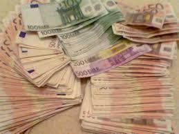 Stosy banknotów euro o różnych nominałach (50, 100, 200 i 500) ułożone chaotycznie na jasnej powierzchni, z widocznymi drobnymi zagnieceniami i różnicami w ułożeniu.