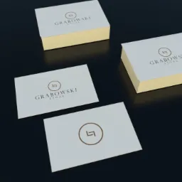 Wizytówki kancelarii prawnej Grabowski Legal z logo i złotymi brzegami, ułożone na ciemnym tle.