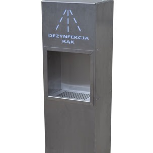 Metalowa kolumna do dezynfekcji rąk z napisem 'DEZYNFEKCJA RĄK' i symbolem rozpylania, wykończona w stali nierdzewnej, z widocznym otworem na ręce i kratką odpływową.