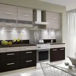 Jasna kuchnia z brązowymi akcentami, fronty szafek w dwóch odcieniach, oświetlenie podszafkowe, biały okap i lodówka, na stole szklany serwis do herbaty.