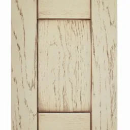 Fragment kremowej drewnianej płyciny drzwiowej z wyraźnym usłojeniem i postarzanym wykończeniem, widok z bliska.