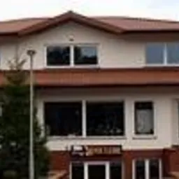 Panorama salonu firmowego z ekspozycją lamp stołowych z abażurami oraz z modułami punktów świetlnych na tle budynku.