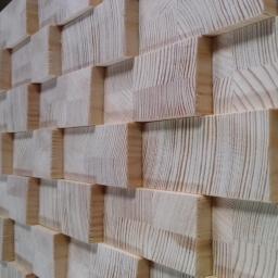 dor san art - Drewniana mozaika ścienna z jasnych, kwadratowych klocków o wyraźnym usłojeniu, tworzących trójwymiarowy wzór.