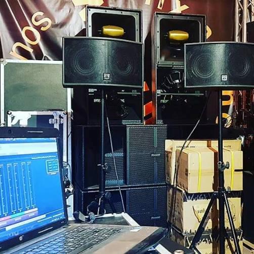 Profesjonalny zestaw nagłośnieniowy z laptopem sterującym, gotowy do użycia w Warszawie. Widoczne głośniki na statywach, wzmacniacze i okablowanie.
