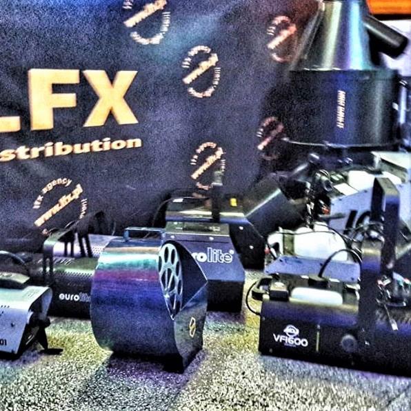 Zestaw urządzeń oświetleniowych i efektów specjalnych, w tym wytwornice dymu Eurolite i VR600, na tle baneru reklamowego z logo FX Distribution i motywem przekreślonego ducha.