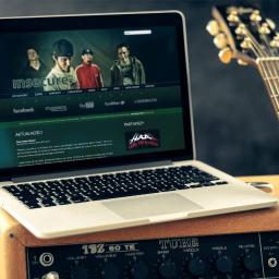 Studio Websteady - Laptop wyświetlający stronę zespołu muzycznego 'Insecure', ustawiony na wzmacniaczu gitarowym obok gitary elektrycznej.