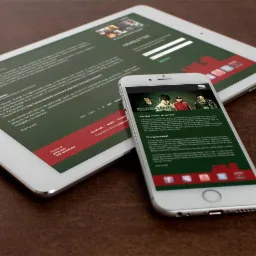 Prezentacja strony internetowej zespołu muzycznego na smartfonie i tablecie, z widocznymi detalami dotyczącymi koncertu i aktualności.