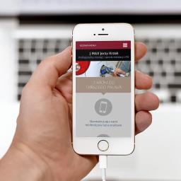 Studio Websteady - Smartfon w dłoni wyświetlający stronę internetową firmy J MAX Jerzy Krzak oferującej montaż i serwis instalacji LPG, z widocznym menu, zdjęciem instalacji LPG i wezwaniem do kontaktu.
