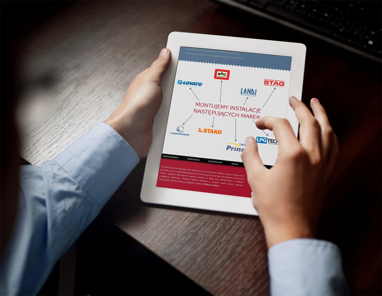 Osoba przegląda na tablecie stronę internetową prezentującą marki instalacji LPG, z widocznymi logotypami BRC, Lovato, Stag, Landi, Stako, Prins i LPG Tech.