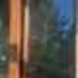 Fragment drewnianej konstrukcji antresoli z widocznymi belkami i elementami mocującymi, oświetlony ciepłym światłem, z rozmytym tłem sugerującym wnętrze budynku w trakcie budowy lub remontu.