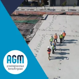 Grupa inżynierów w kamizelkach odblaskowych i kaskach na placu budowy, widok z góry, z widocznym zbrojeniem i elementami betonowymi, logo firmy konsultingowej w lewym dolnym rogu.