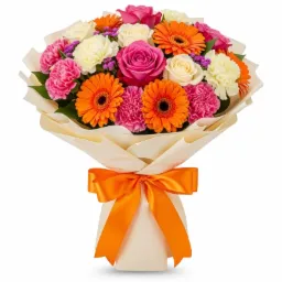 Barwny bukiet z róż, gerber i goździków, owinięty kremowym papierem i przewiązany pomarańczową wstążką, na białym tle. Idealny prezent na każdą okazję.