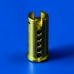 Mosiężny element cylindryczny z precyzyjnie wykonanymi otworami i nacięciem na górze, sfotografowany na jednolitym niebieskim tle.