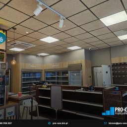 PRO-CON SERWIS Klimatyzacja Wentylacja Rekuperacja - Wnętrze lokalu handlowego z widocznymi systemami wentylacji podwieszonymi pod sufitem, oświetleniem punktowym i kratką wentylacyjną, z pustymi regałami chłodniczymi na piwo i napoje.