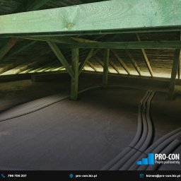 PRO-CON SERWIS Klimatyzacja Wentylacja Rekuperacja - Instalacja przewodów wentylacyjnych w przestrzeni poddasza z drewnianą konstrukcją nośną, widoczne rury karbowane prowadzone po podłodze.