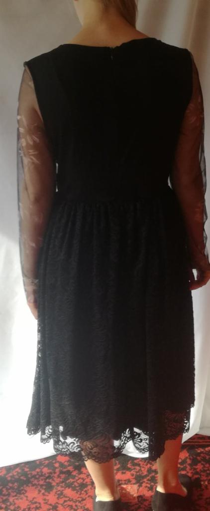 Czarna, koronkowa sukienka z tiulowymi rękawami, widok z tyłu, zamek błyskawiczny na plecach.