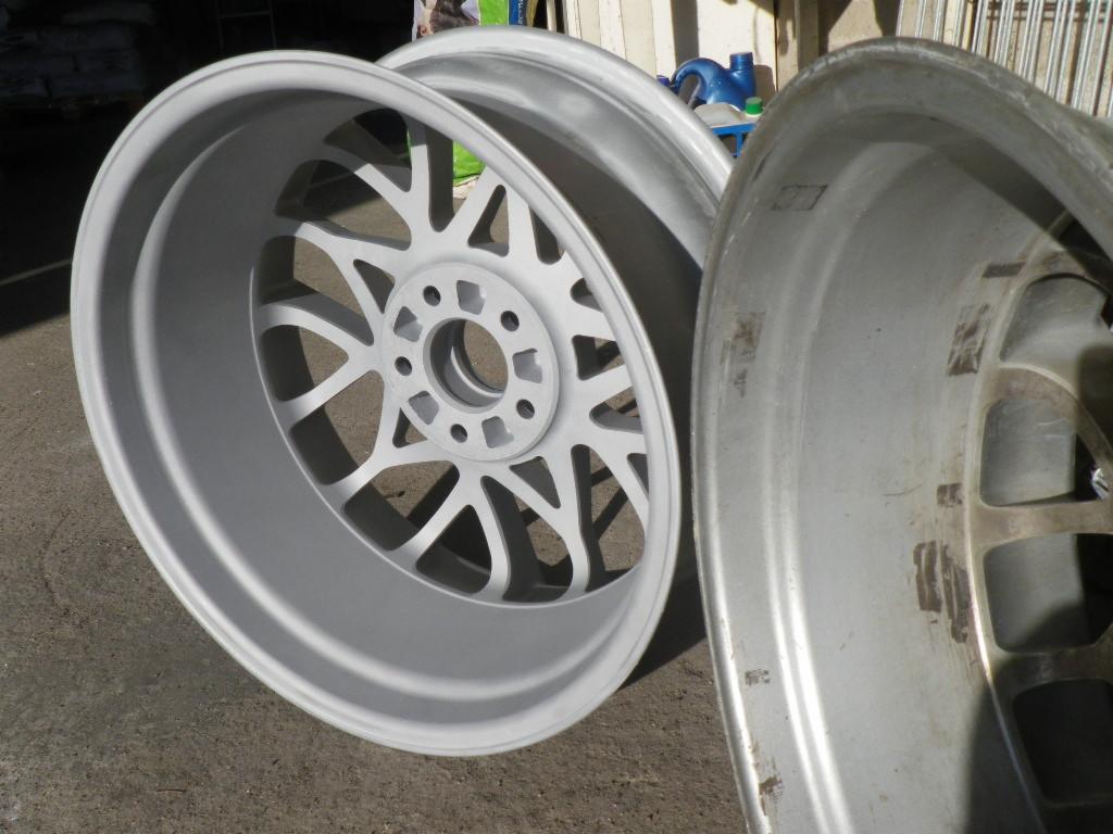 Dwa felgi samochodowe: jedna po piaskowaniu i malowaniu na srebrno, druga przed obróbką, widoczne ślady korozji. Usługa wykonana w Rydzynie.