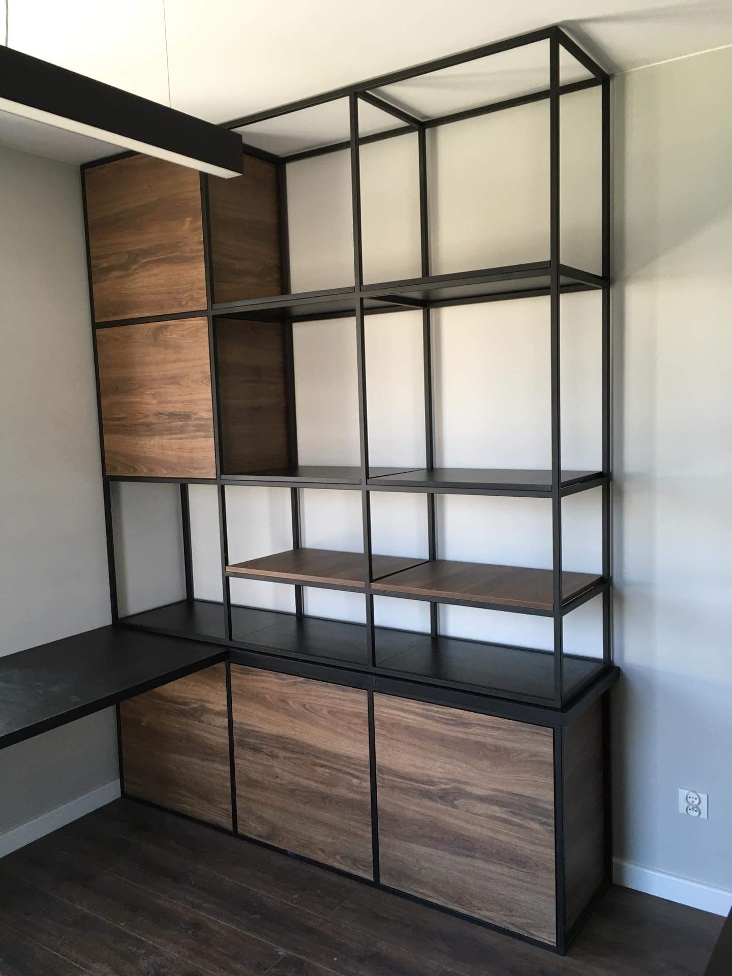 Regał z czarnej stali z drewnianymi elementami, połączony z biurkiem, widok z dołu, minimalistyczny design.