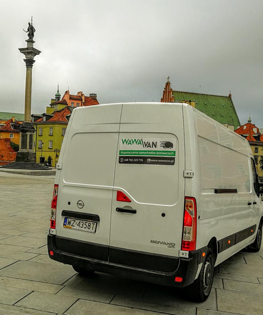 Biały samochód dostawczy WawaVan na tle kolumny Zygmunta w Warszawie, widoczny numer telefonu i adres strony internetowej.