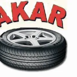 Opona samochodowa z widocznym bieżnikiem i felgą, nad nią czerwony napis AKAR, całość na białym tle.