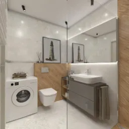Nowoczesna łazienka z pralką, umywalką w szarym blacie z szafkami, wiszącą toaletą, płytkami imitującymi drewno i obrazkami z motywem latarni morskiej.