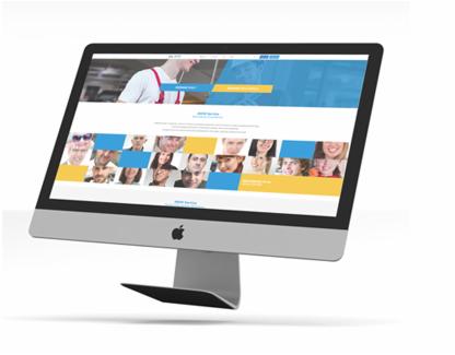 Monitor iMac wyświetlający stronę internetową z motywem niebiesko-żółtym i zdjęciami zespołu, ustawiony pod kątem na białym tle.