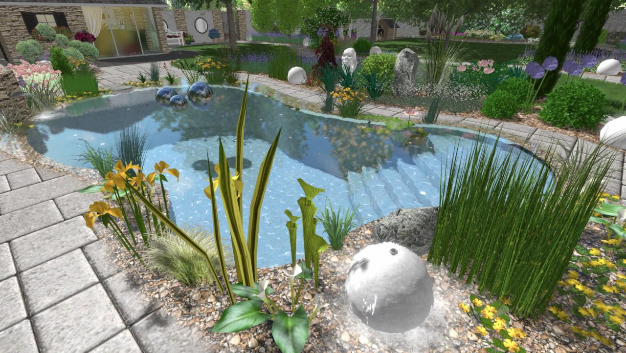 Oczko wodne z kaskadą, otoczone kamienną ścieżką i różnorodną roślinnością, w tym żółtymi irysami i trawami ozdobnymi, z białymi kulami dekoracyjnymi i widokiem na dom z ogrodem w tle.