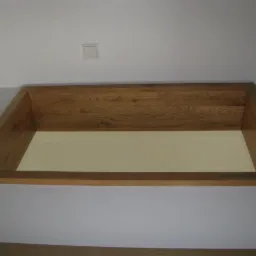 Drewniana rama antresoli, widok z dołu na białe wnętrze wnęki, z widocznym oświetleniem sufitowym w tle.