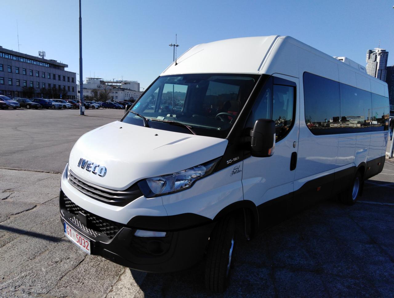 Biały bus Iveco 50-180 na parkingu z budynkami w tle, widoczna tablica rejestracyjna G1 5032.