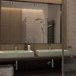 Nowoczesna łazienka z dwoma umywalkami o prostokątnym kształcie, drewnianą boazerią i geometryczną podłogą, widziana przez szklaną kabinę prysznicową.