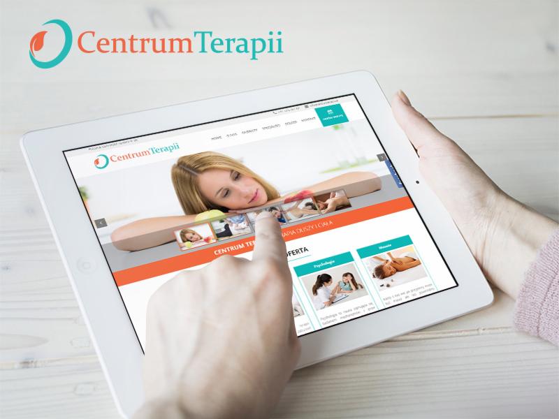 Prezentacja strony internetowej Centrum Terapii na białym tablecie trzymanym w dłoniach, z palcem wskazującym na ekran.