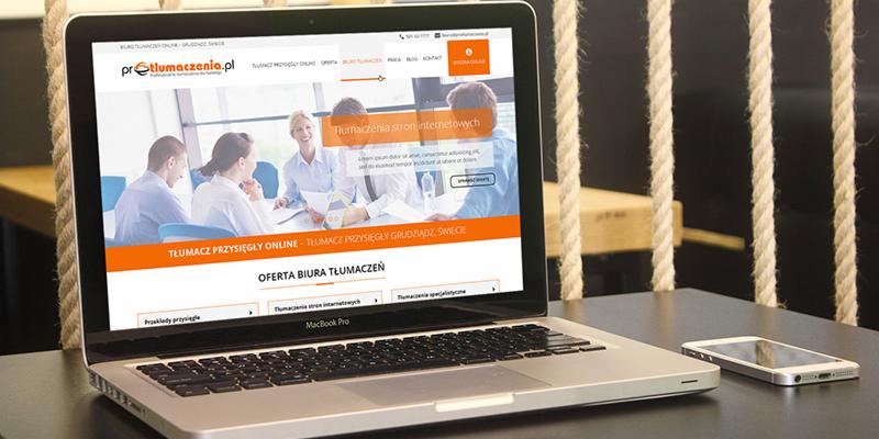 MacBook Pro wyświetlający stronę internetową biura tłumaczeń protlumaczenia.pl, obok smartfon na ciemnym blacie, w tle liny dekoracyjne.