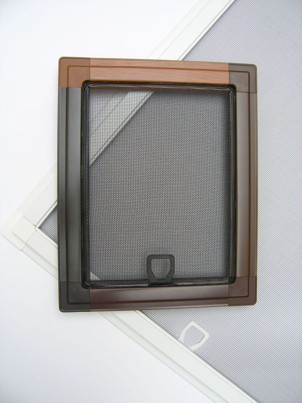 Brązowa ramka z siatką przeciw owadom, widoczne uchwyty, na białym tle z fragmentami innych ramek z siatkami.