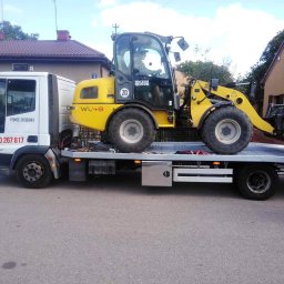 LAWETA Pomoc Drogowa TUCHÓW Transport HOLOWANIE - Laweta z Ryglice transportuje żółtą ładowarkę Wacker Neuson WL48 na platformie. Widoczny numer telefonu 'Pomoc Drogowa' na kabinie lawety.