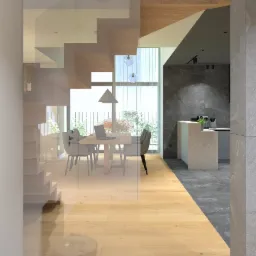 Nowoczesne wnętrze domu z drewnianą podłogą, przeszklonymi schodami i widokiem na jadalnię oraz kuchnię w odcieniach szarości.