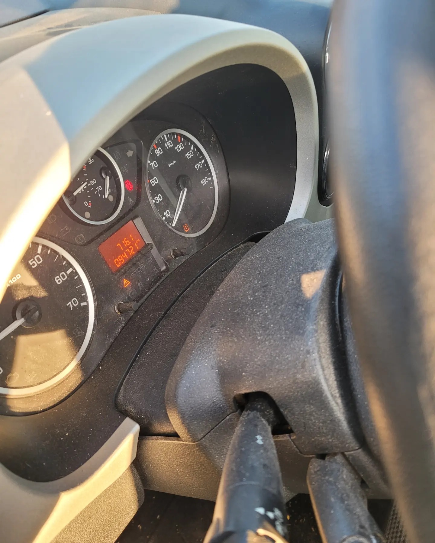 Brudny kokpit samochodu z widocznym licznikiem kilometrów i prędkościomierzem. Wnętrze auta zaniedbane, wymagające czyszczenia.