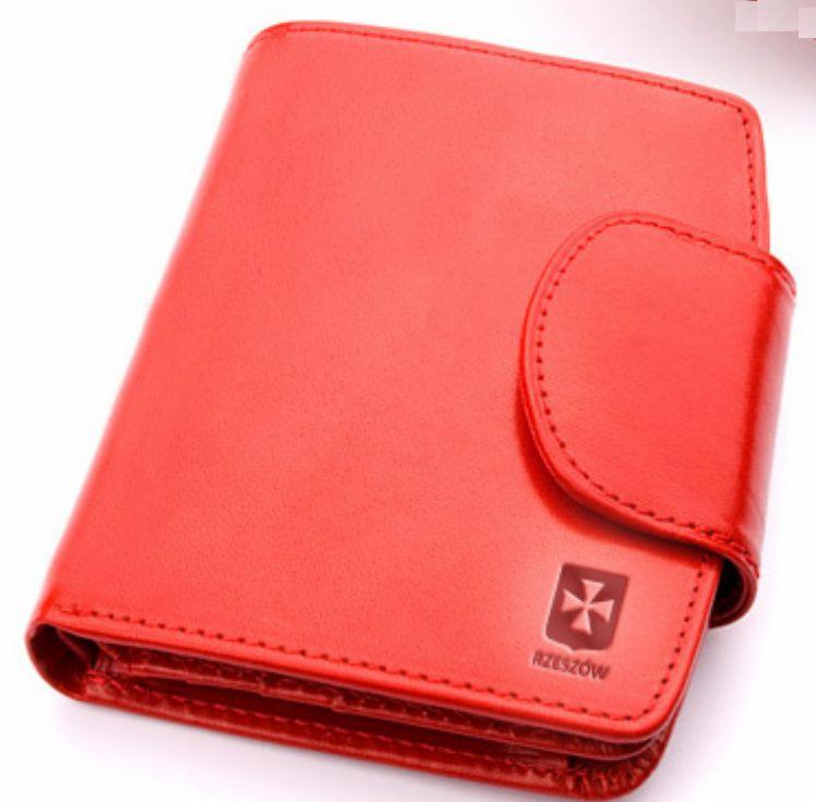 Czerwony, skórzany portfel z wytłoczonym herbem i napisem Rzeszów, widoczny z bliska.