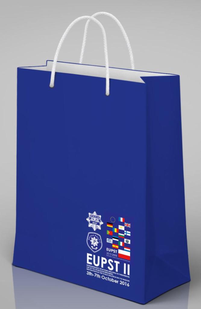 Granatowa torba papierowa z białymi uchwytami, nadrukowanym logo policyjnym EUPST II i flagami państw członkowskich UE.