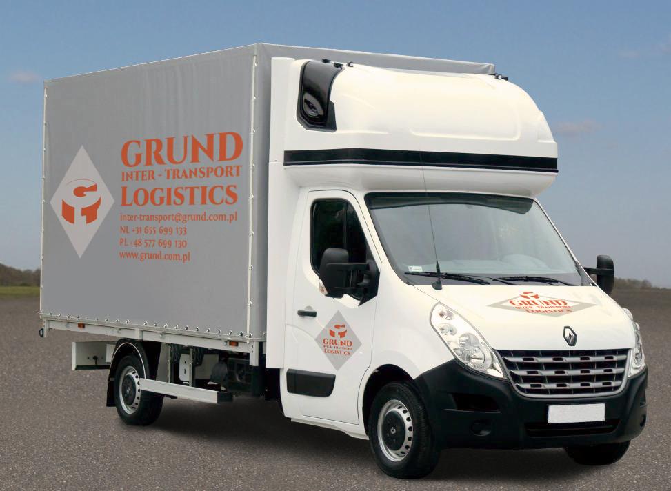 Biała furgonetka transportowa z szarą plandeką, na której widnieje pomarańczowe logo firmy Grund Inter-Transport Logistics wraz z danymi kontaktowymi, zaparkowana na asfaltowej drodze na tle pola...