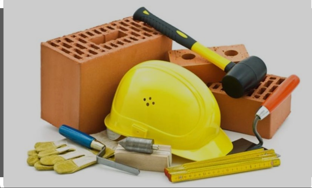 Cegły modularne, żółty kask budowlany, kielnia z pomarańczową rączką, gumowy młotek z żółtym trzonkiem, poziomica, miara składana i rękawice robocze na neutralnym tle.