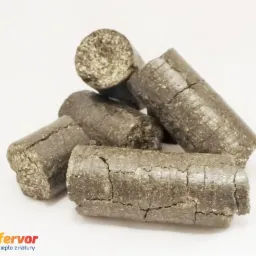Kilka walcowatych brykietów na białym tle, widoczne drobne pęknięcia na powierzchni, w lewym dolnym rogu logo producenta.