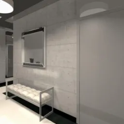 Wnętrze korytarza z betonową ścianą, lustrem w srebrnej ramie, białą ławką z pikowanym siedziskiem i białymi drzwiami na końcu korytarza.